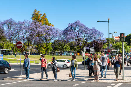 Lisbon, Portugal - May 19, 2017: People waiting to cross street in Lisbon, Portugal. Blossoming...