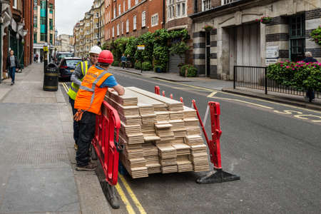 London, UK - May 23, 2017: Unidentified workmen with a flooring stand on the street in London, England, United Kingdom.のeditorial素材