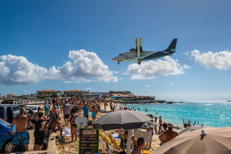 Maho beach, Saint Martin - December 17, 2018: The Air Cargo Carriers transport aircraft Short 360 approaches Princess Juliana airport above onlooking spectators in Maho beach, Sint Maarten - Saint Martin island.のeditorial素材