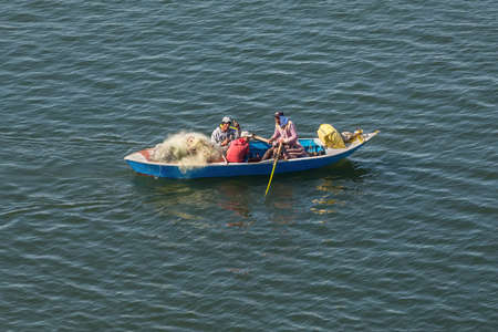 Ismailia, Egypt - November 5, 2017: Fishermen in wooden boat catch fish net on the New Suez Canal, Ismailia, Egypt, Africa.のeditorial素材