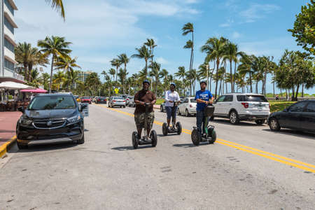 Miami, FL, USA - April 19, 2019: Tourists on segways on the Ocean Drive street in the historical Art...
