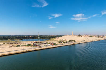 Ismailia, Egypt - November 5, 2017: Military built and telecommunication tower on the shore of the Suez Canal near Ismailia, Egypt, Africa. Suez Canal Defence Monument in the background.のeditorial素材