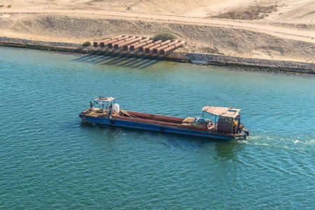 Ismailia, Egypt - November 5, 2017: Barge with local workers passes through the Suez Canal near Ismailia, Egypt, Africa.のeditorial素材