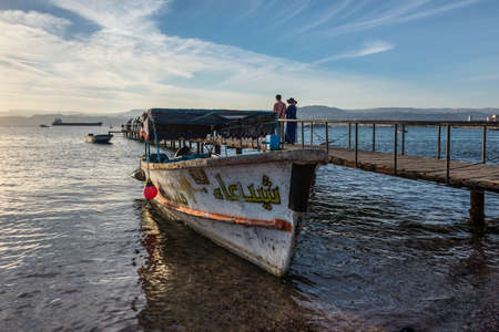 Aqaba, Jordan - November 6, 2017: Red Sea with a tourist wooden glass boat on Al-Ghandour Beach in Aqaba, Jordan.のeditorial素材