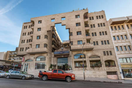 Aqaba, Jordan - November 6, 2017: Street view of Aqaba at day with parked cars near tourist shops and Crystal Hotel in Aqaba, Jordan.のeditorial素材
