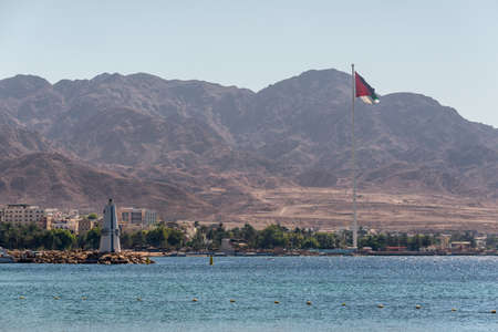 Aqaba, Jordan - November 6, 2017: View of the lighthouse and giant flag in Aqaba port in Jordan. The port's location linking Africa and the Middle East.のeditorial素材
