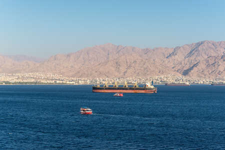 Eilat, Israel - November 7, 2017:  View from cargo port of Eilat in Israel on Jordanian mountains and anchored ships at the gulf of Aqaba (Red Sea). Tourist boats sail in the bay.のeditorial素材