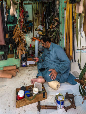 Salalah, Sultanat of Oman - November 12, 2017: Man selling handmade leather goods at the Souq in Salalah, Oman, Indian Ocean.のeditorial素材