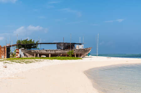 Maafushi Island, Maldives - November 17, 2017: An old wooden fishing boat on the coast of the Maafushi Island, Maldives. Paradise tropical island. Travel and tourism concept.のeditorial素材