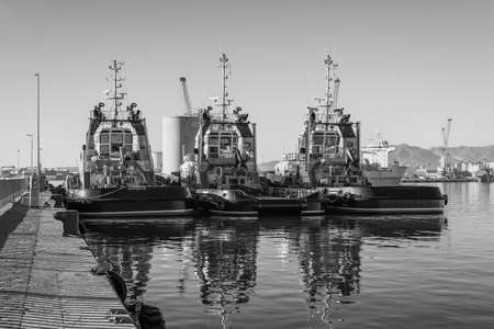 Malaga, Spain - December 4, 2018: Sea tugboats moored in the port of Malaga, Andalusia, Spain. Black and white photography.のeditorial素材