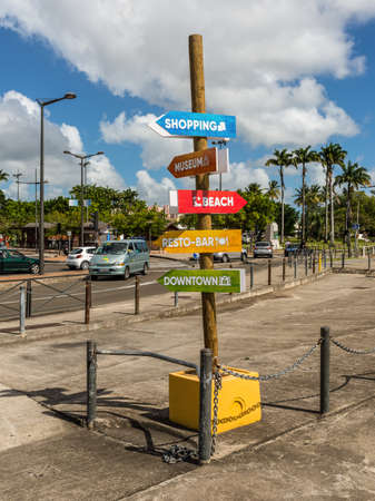 Fort-de-France, Martinique - December 13, 2018: Pillar with pointers (inscriptions) on a colorful background: shopping, Museum, Beach, Resto-bar, Downtown in the city of Fort-de-France, France's Caribbean overseas department of Martinique.のeditorial素材