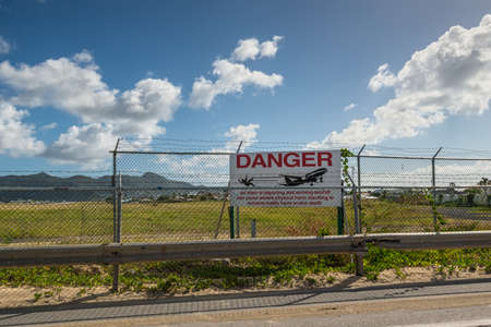 Simpson bay, Saint Maarten - December 17, 2018: View of sign Danger near the Princess Juliana International Airport next to Maho Beach on the Dutch side of St. Martin.のeditorial素材