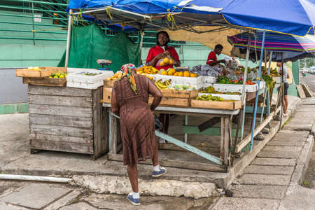 St John's, Antigua and Barbuda - December 18, 2018: Vendors fresh fruit and vegetable on a local market in St. John's, Antigua, West Indies, Caribbean.のeditorial素材