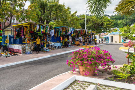 Ocho Rios, Jamaica - April 22, 2019: Souvenir street market in the tropical Caribbean island of Ocho Rios, Jamaica. Flowerbed in the foreground.のeditorial素材