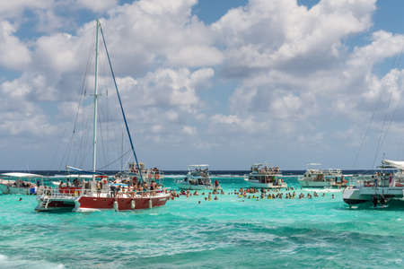 George Town, Grand Cayman Islands, United Kingdom - April 23, 2019: People enjoy playing with the stingrays at the sandbar of Stingray city on Gran Cayman in Cayman islands.のeditorial素材
