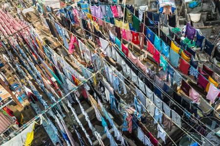 Mumbai, India - November 22, 2019: Colourful shirts and clothes hanging to dry at Dhobi Ghats central laundry.  It was constructed in 1890.のeditorial素材