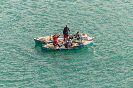 El Qantara, Egypt - November 14, 2019: Fishermen in wooden boat on the Suez Canal in Egypt.