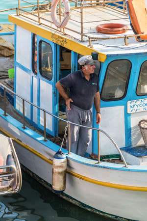 Heraklion, Greece - November 12, 2019: A unidentified boatman standing in a wooden fishing boat in port of Heraklion, Crete Island, Greece.のeditorial素材