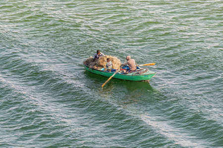El Qantara, Egypt - November 14, 2019: Fishermen in wooden boat on the Suez Canal in Egypt.