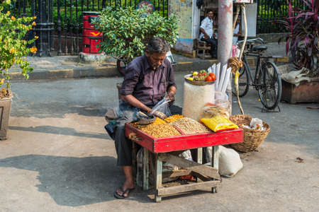Mumbai, India - November 22, 2019: Indian man selling nuts at a street market in Mumbai (colloquially known as Bombay), India.のeditorial素材