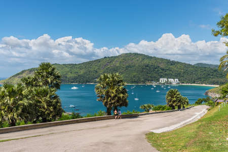 Phuket, Thailand - November 29, 2019: Tourists and beautiful seascape view from view point in Phuket, Thailand.. Exotic turquoise ocean with boats, blue sea, blue sky and Nai Han Beach.のeditorial素材