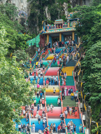 Kuala Lumpur, Malaysia - December 2, 2019: Travelers climb the colorful steps leading to a hindu temple in a cave in mountains near Kuala Lumpur, Malaysia. Batu Caves entrance stairs.のeditorial素材
