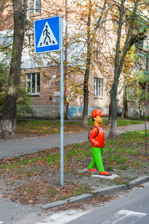 Kyiv, Ukraine - October 11, 2020: View of orange plastic mannequin boy near a pedestrian crossing in Kyiv, Ukraine, Europe. Pedestrian safety.のeditorial素材
