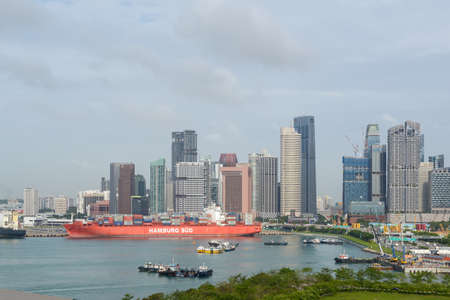 Singapore - December 3, 2019:  Cityscape and view of port of Singapore from the cruise terminal. The container vessel Santa Catarina is in the center.のeditorial素材