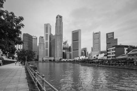 Singapore - December 3, 2019:  Singapore city skyline of business district downtown and Singapore river in cloudy weather. Black and white photo in retro style.のeditorial素材
