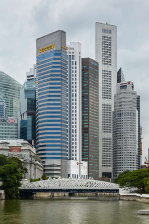 Singapore - December 3, 2019:  Singapore skyscrapers with white Anderson Bridge and a few towers of financial district near esplanade park. Some green foliage on both sides.のeditorial素材