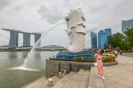 Singapore - December 3, 2019: Merlion statue fountain in Merlion Park Singapore city in cloudy weather. Merlion fountain is one of the most famous tourist attraction in Singapore.のeditorial素材