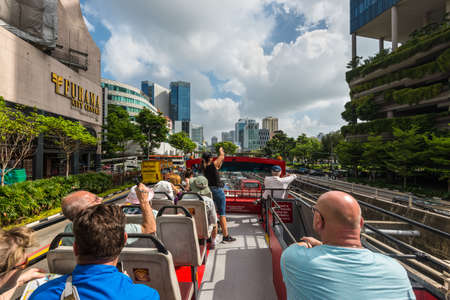 Singapore - December 4, 2019: People look at the sights of Singapore by Hop-on Hop-off bus - go along the Tong Sen street in Singapore.のeditorial素材
