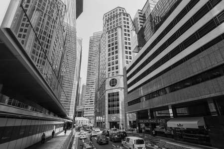 Singapore - December 4, 2019: Street scene in Singapore with the office buildings tall skyscraper and traffic in the financial center of Singapore. Black and white photography in retro style.のeditorial素材