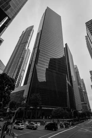 Singapore - December 4, 2019: Street scene in Singapore with the office buildings tall skyscraper in the financial center of Singapore. Black and white photography in retro style.のeditorial素材