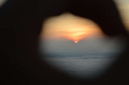 Sunrise through my handの写真素材