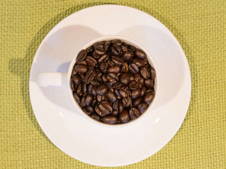 coffee beans in mug with green table clothの写真素材