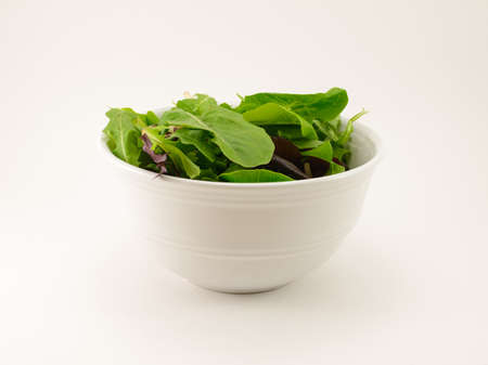 Mixed Salad Greens in a White bowl isolated on a white backgroundの写真素材