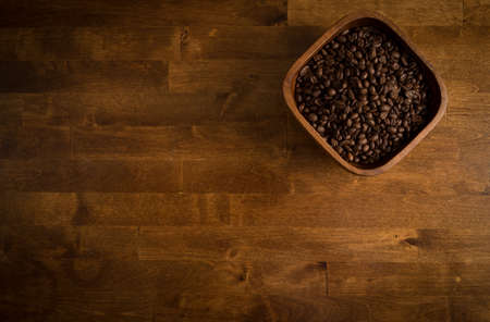 Coffee Beans in a bamboo bowl on a wooden table.の写真素材