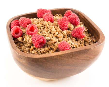 Cinnamon granola with raspberries in a wooden bowl.の写真素材