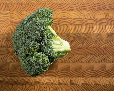 Green broccoli on a wooden cutting board board.