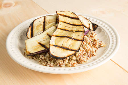 Grilled Eggplant with Quinoa on a wooden table.の写真素材