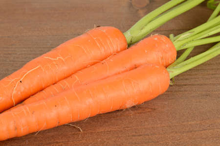 A bunch of carrots on a wood table.の写真素材