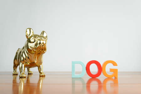 A dog statue on a wooden table with dog spelled out.の写真素材