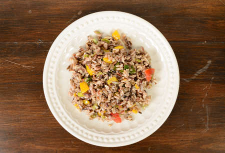 A plate of rice cooked with red and yellow pepersの写真素材