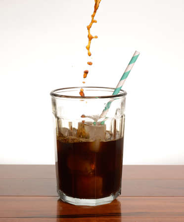 coffee being poured into a glass filled with iceの写真素材