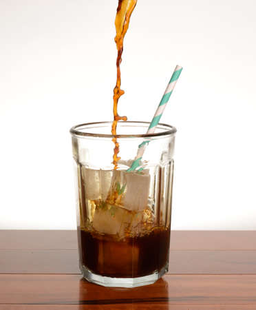 coffee being poured into a glass filled with iceの写真素材