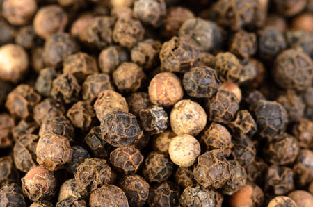 A close-up of whole unground black peppercorn.