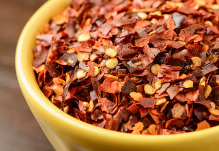 Close-up of crushed red pepper in a yellow bowl.の写真素材
