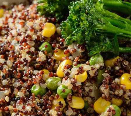 A close up of a quinoa bowl with broccoli, corn, and peasの写真素材