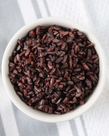 Fresh cooked black rice in a white bowl.の写真素材